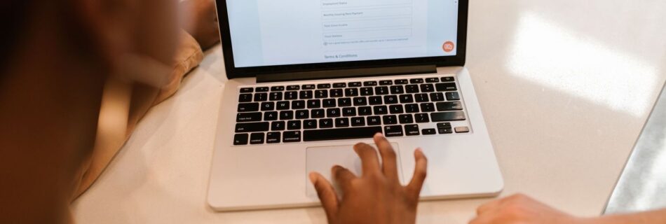 Person fyller i ett digitalt formulär på en bärbar dator
