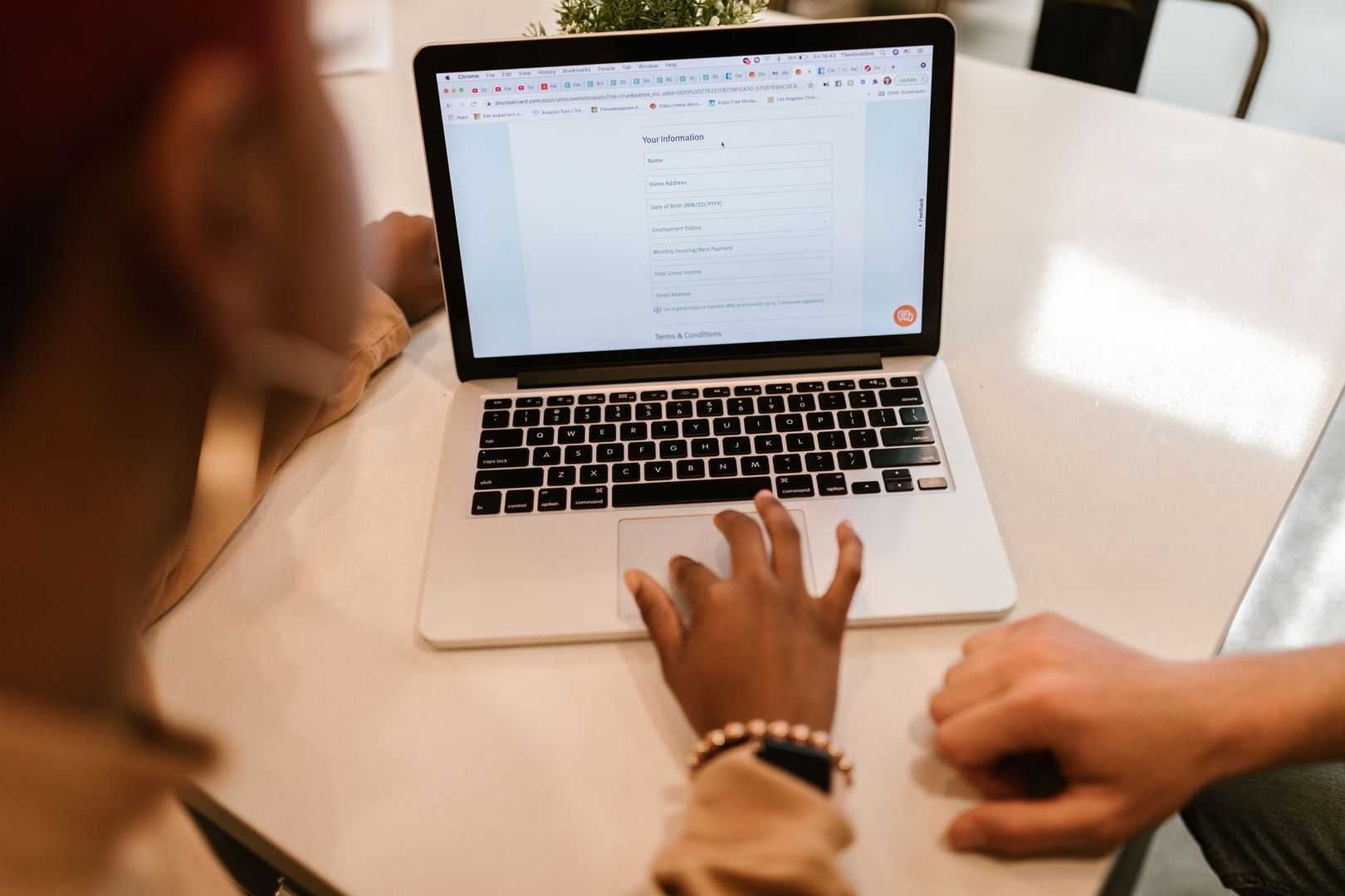 Person fyller i ett digitalt formulär på en bärbar dator